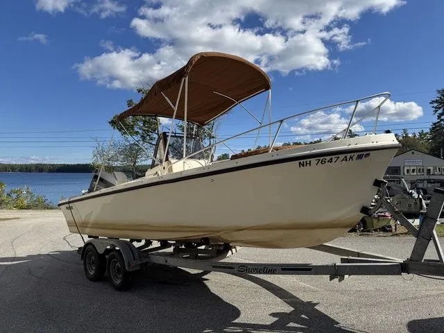 Slide: The Image of 1990 Mako 201 boat on trailer by lake under blue sky. - 7