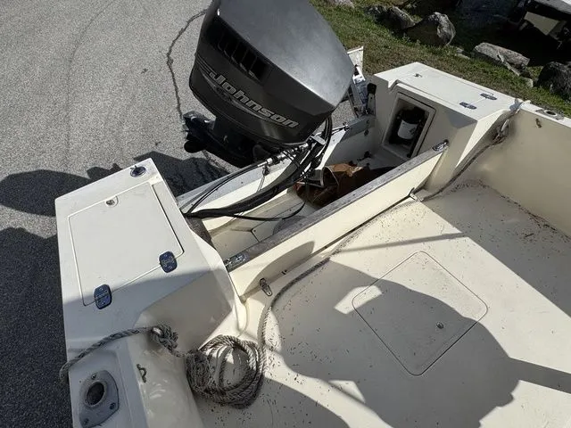 Slide: The Image of 1990 Mako 201 boat with Johnson outboard motor, showing interior and engine area. - 8