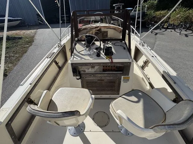 Slide: The Image of 1990 Mako 201 boat interior with steering wheel, two seats, and control panel. - 9