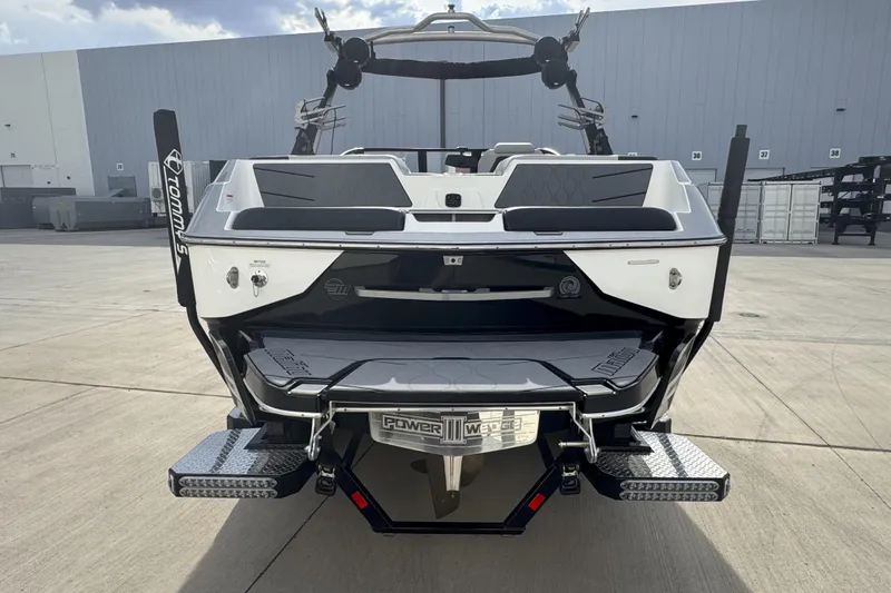 Slide: The Image of 2023 Malibu M220 boat rear view in industrial setting. - 7