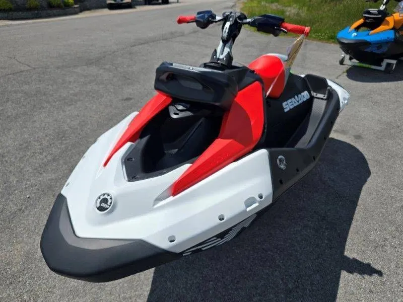 Slide: The Image of 2026 Sea-Doo Spark Trixx jet ski in red and white on asphalt. - 27