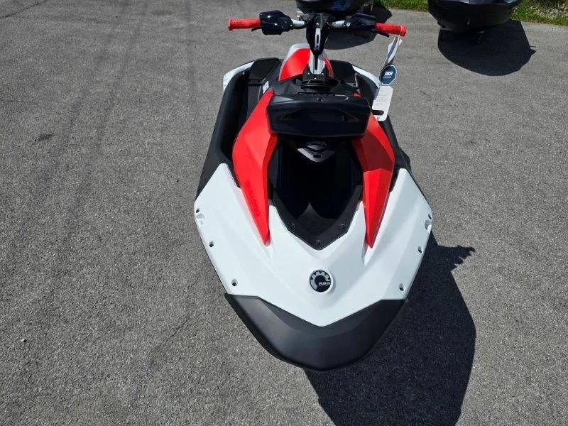 Slide: The Image of 2026 Sea-Doo Spark Trixx jet ski in red and white on asphalt. - 29