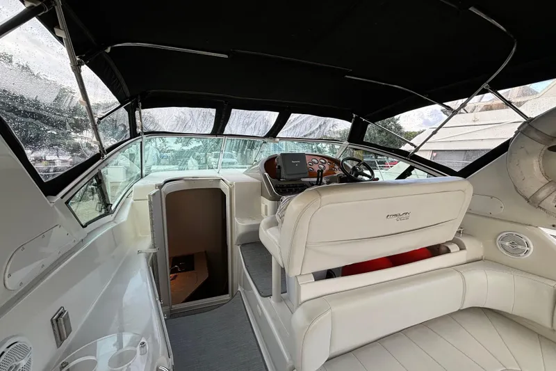 Slide: The Image of 1999 Trojan 320 Express boat interior with helm, seating, and cabin entrance. - 12