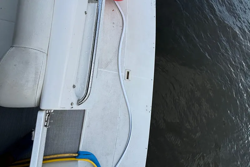 Slide: The Image of 1999 Trojan 320 Express boat deck with white seating and water view. - 15