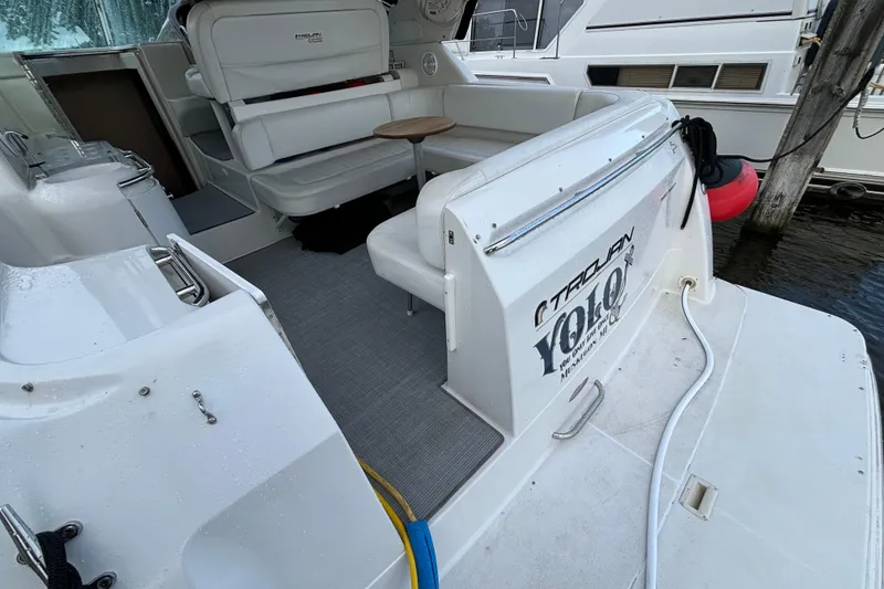 Slide: The Image of 1999 Trojan 320 Express yacht interior with seating and table at dock. - 16