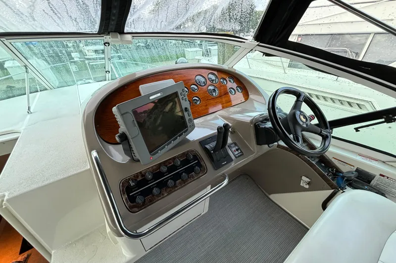 Slide: The Image of 1999 Trojan 320 Express boat helm with steering wheel and navigation controls. - 18