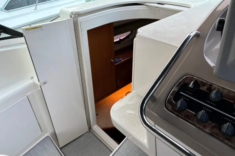 Slide: The Image of 1999 Trojan 320 Express boat interior with control panel and cabin entrance. - 19