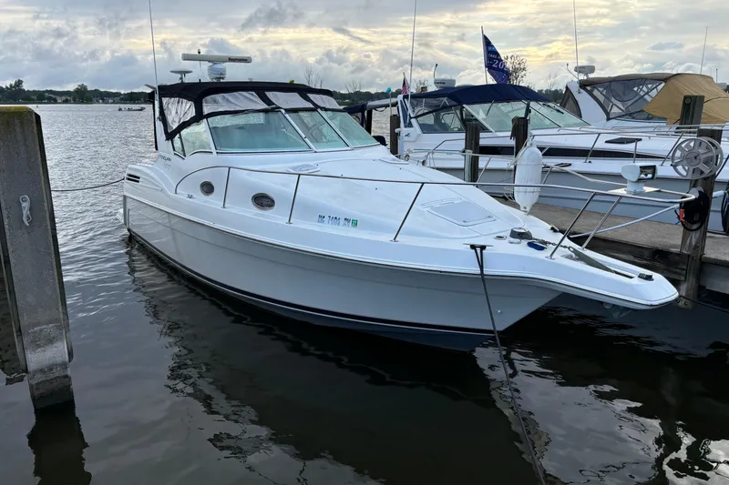Slide: The Image of 1999 Trojan 320 Express boat docked at marina, overcast sky, calm water. - 2