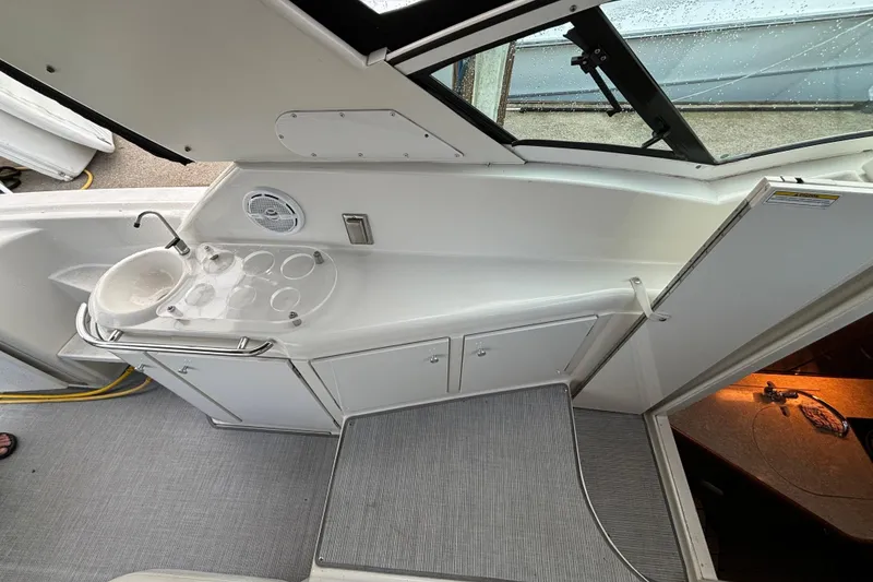 Slide: The Image of 1999 Trojan 320 Express boat interior with sink and cup holders. - 20