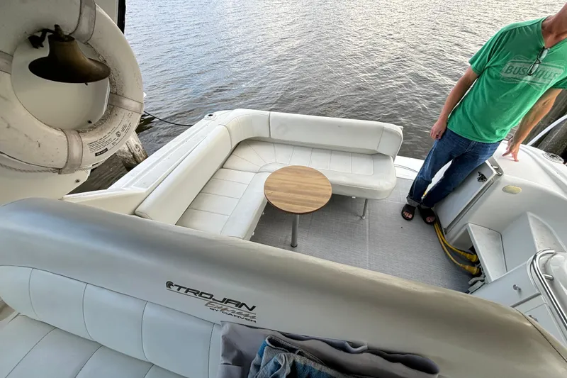 Slide: The Image of 1999 Trojan 320 Express boat interior with white seating and small round table. - 21
