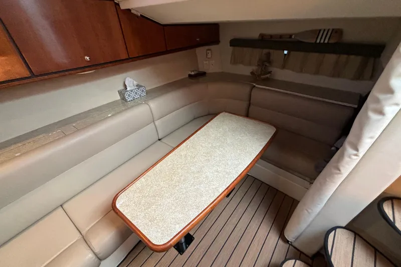 Slide: The Image of 1999 Trojan 320 Express cabin interior with beige seating and wooden table. - 23