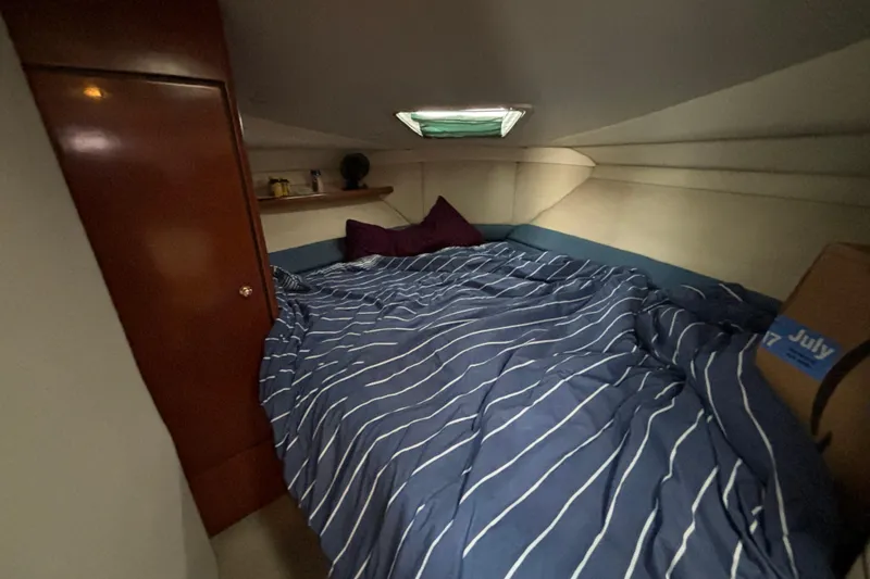 Slide: The Image of Cozy cabin interior of 1999 Trojan 320 Express with striped bedding and wooden accents. - 26