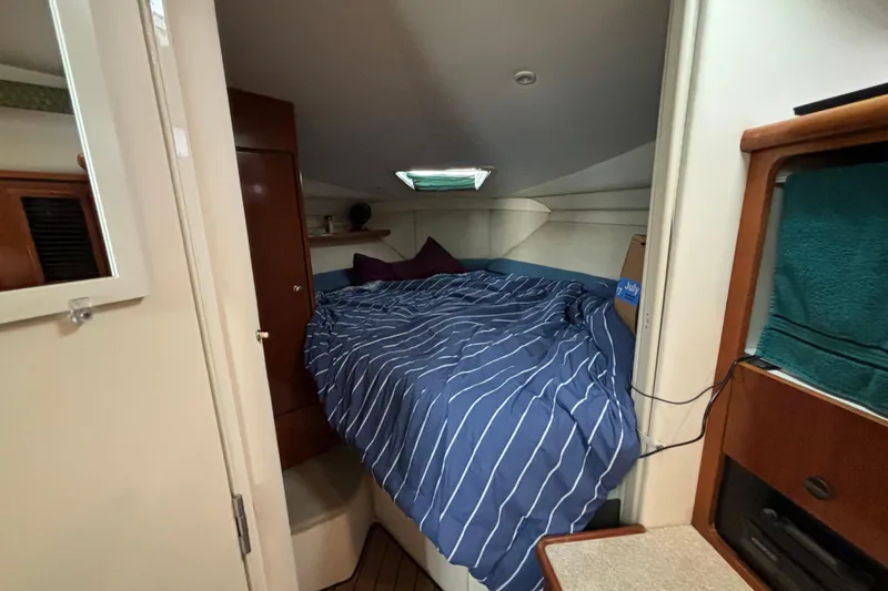 Slide: The Image of 1999 Trojan 320 Express cabin interior with cozy bed and striped bedding. - 27