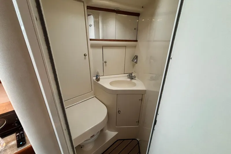 Slide: The Image of Compact bathroom in 1999 Trojan 320 Express boat with sink and storage cabinets. - 29