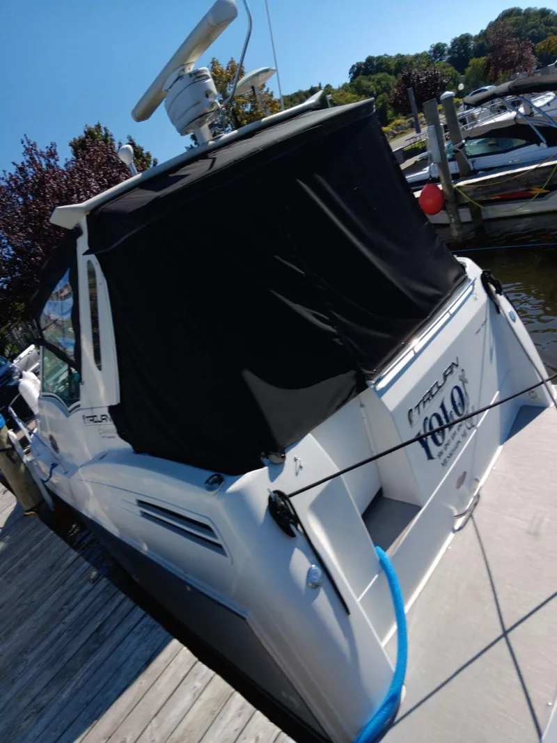 Slide: The Image of 1999 Trojan 320 Express boat docked, featuring a black canopy and radar equipment. - 3