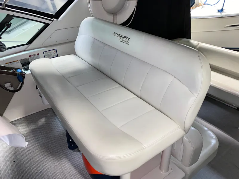 Slide: The Image of White leather seating in a 1999 Trojan 320 Express boat interior. - 8
