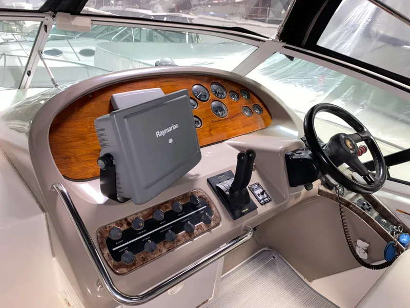 Slide: The Image of 1999 Trojan 320 Express boat dashboard with steering wheel and navigation controls. - 9