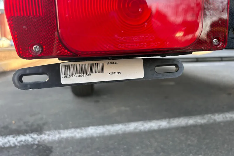 Slide: The Image of Close-up of a 2026 Sun Tracker Bass Buggy 18 DLX trailer light and barcode. - 30