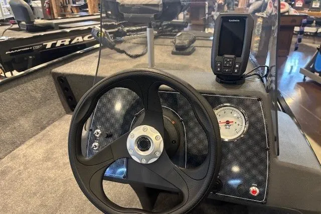 Slide: The Image of 2026 Tracker Bass Tracker Classic XL dashboard with steering wheel and Garmin device. - 66