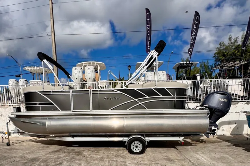 Slide: The Image of 2024 Sylvan 822 LZ pontoon boat with Yamaha engine on trailer, outdoor display. - 14