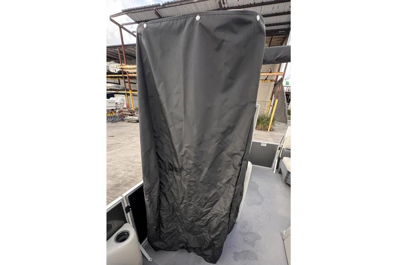 Slide: The Image of 2024 Sylvan 822 LZ boat with black privacy curtain, docked in a marina. - 16