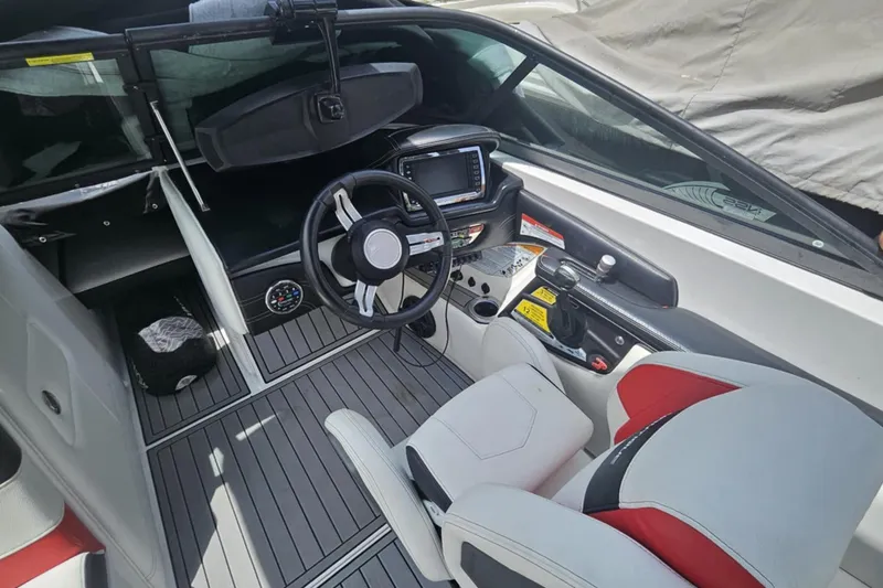Slide: The Image of 2016 Nautique Super Air Nautique 210 boat interior with steering wheel and dashboard controls. - 7