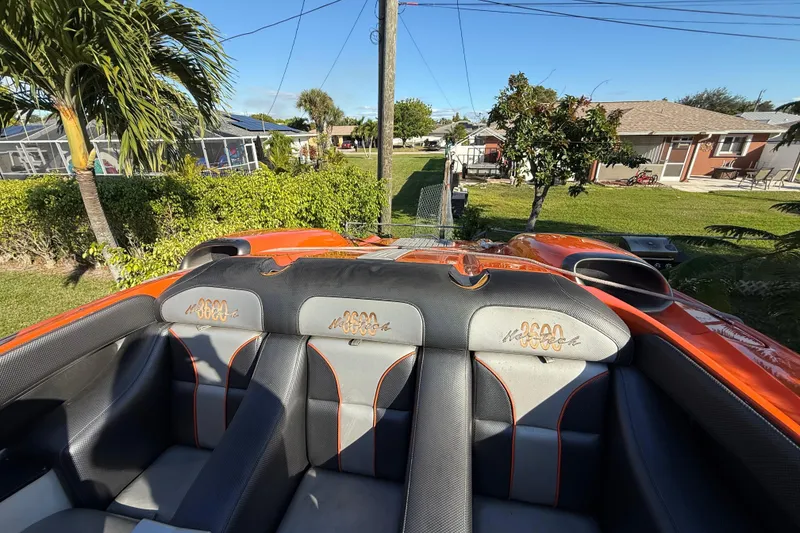 Slide: The Image of 2007 Nor-Tech Supercat 3600 boat interior with orange and black seating, outdoor setting. - 20
