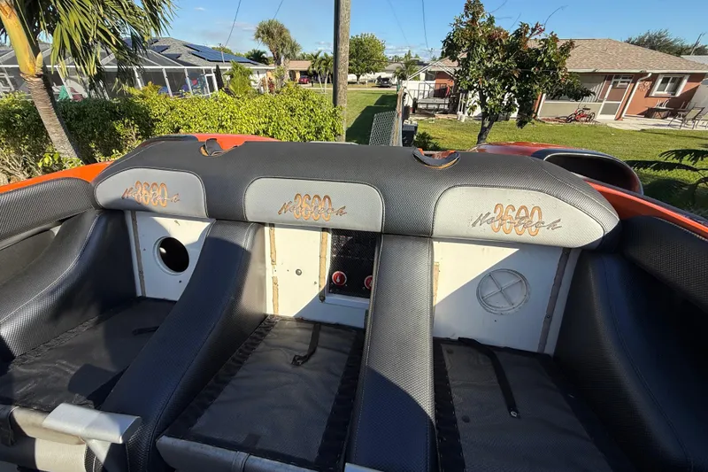Slide: The Image of 2007 Nor-Tech Supercat 3600 interior with black seating and orange accents, outdoor setting. - 21