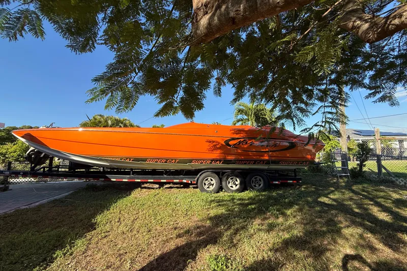 Slide: The Image of 2007 Nor-Tech Supercat 3600 in vibrant orange on a trailer under a tree. - 44