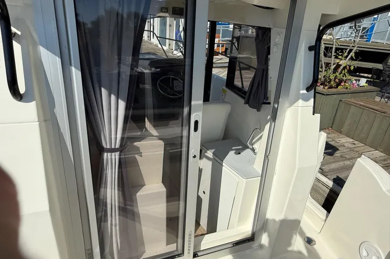 Slide: The Image of 2024 Bayliner Trophy T25 Pilothouse interior with sliding door and compact sink. - 33