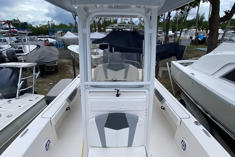 Slide: The Image of 2023 Robalo 226 Cayman boat in marina, surrounded by other vessels. - 4