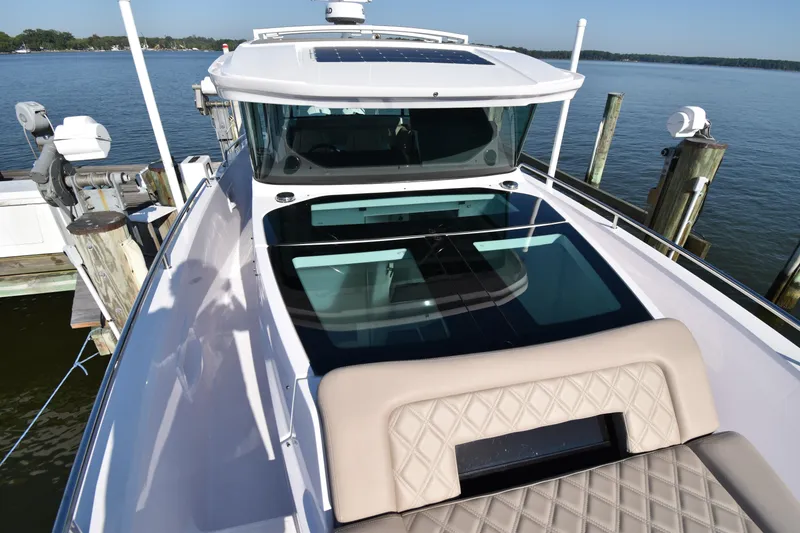 Slide: The Image of 2023 Axopar 37XC Wet Bar boat docked, featuring sleek design and spacious deck. - 10
