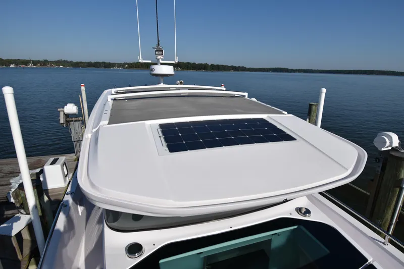 Slide: The Image of 2023 Axopar 37XC Wet Bar with solar panel, docked by a serene lake. - 11