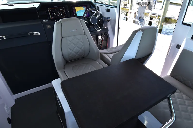 Slide: The Image of 2023 Axopar 37XC Wet Bar interior with modern seating and navigation controls. - 19