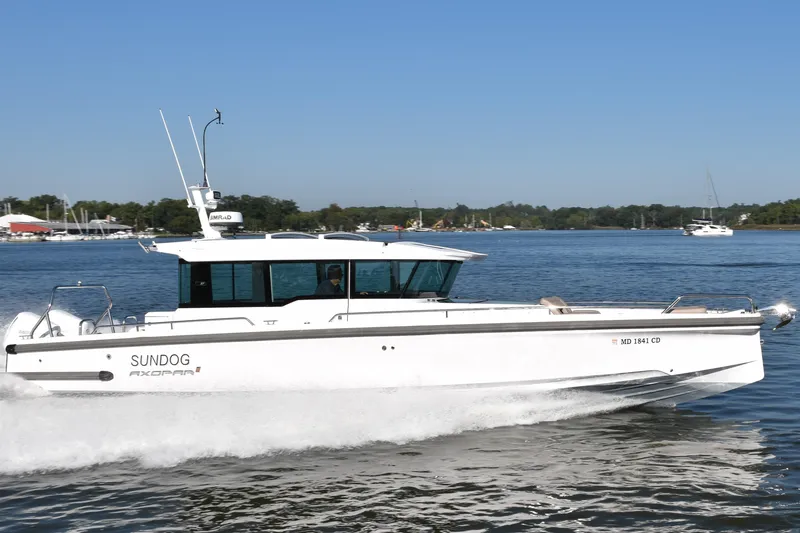 Slide: The Image of 2023 Axopar 37XC Wet Bar boat cruising on a sunny day. - 2