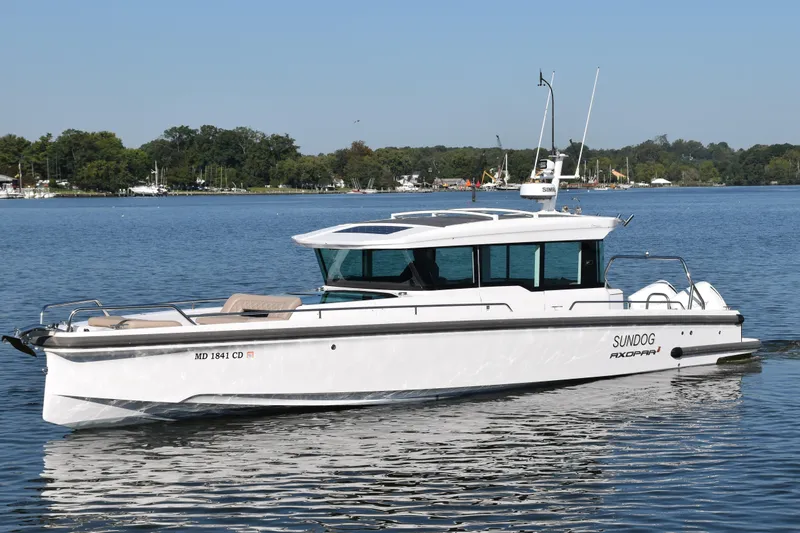 Slide: The Image of 2023 Axopar 37XC Wet Bar boat on calm water, featuring sleek design and modern amenities. - 5