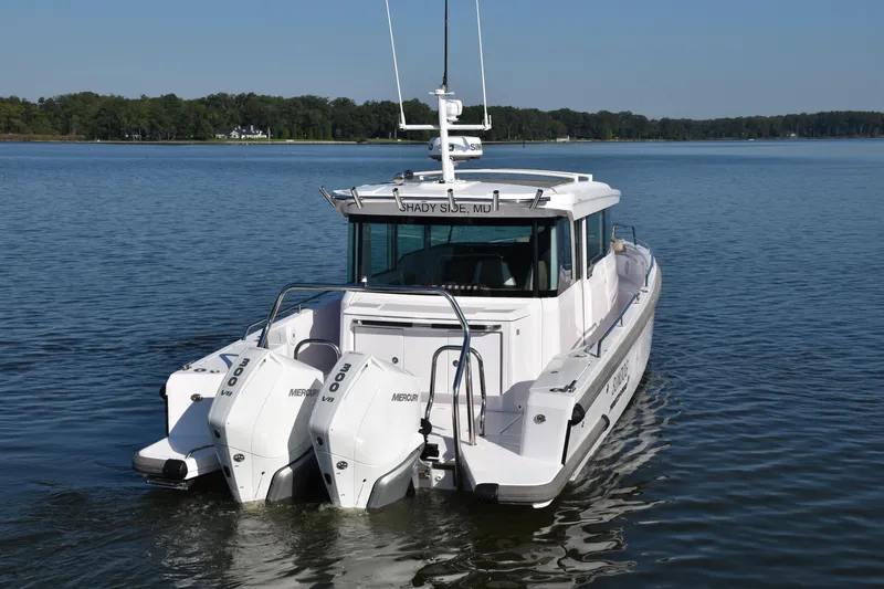 Slide: The Image of 2023 Axopar 37XC Wet Bar boat with dual Mercury engines on a calm lake. - 6
