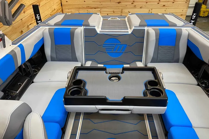 Slide: The Image of 2024 Malibu Wakesetter 23 MXZ interior with blue and gray seating and cup holders. - 10