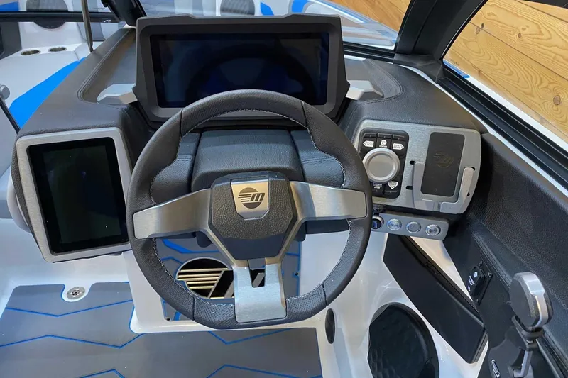 Slide: The Image of 2024 Malibu Wakesetter 23 MXZ dashboard with modern steering wheel and digital displays. - 6