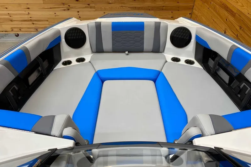 Slide: The Image of 2024 Malibu Wakesetter 23 MXZ interior with blue and gray seating, cup holders, and speakers. - 7
