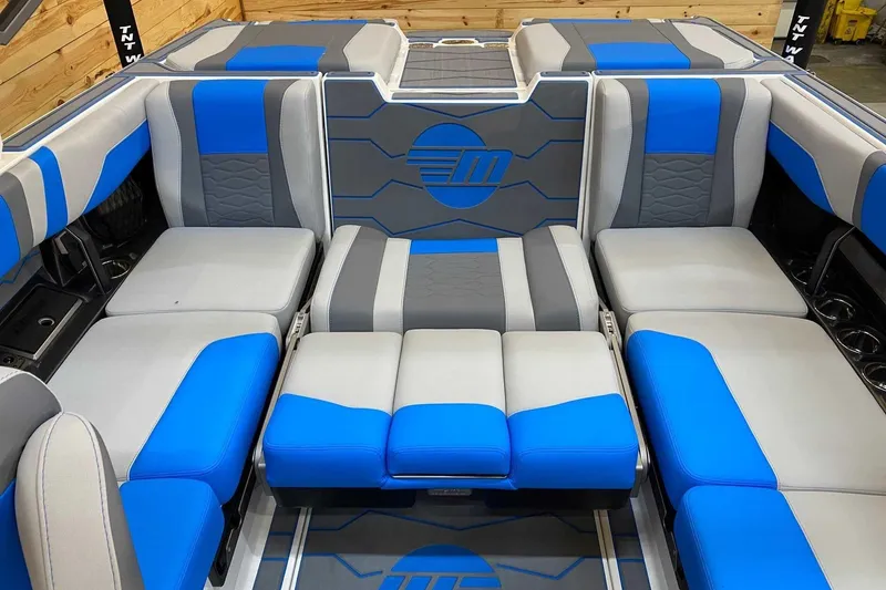 Slide: The Image of 2024 Malibu Wakesetter 23 MXZ interior with blue and gray seating arrangement. - 9