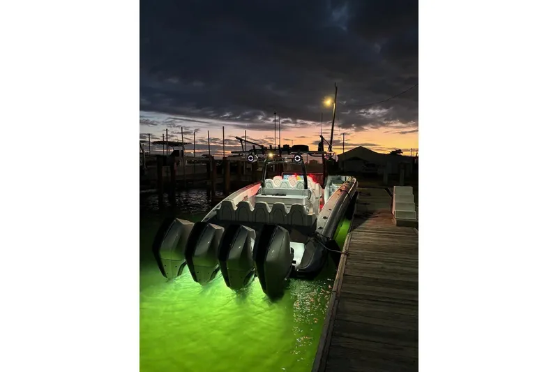 Slide: The Image of 2022 Midnight Express 43 Open boat docked at sunset with illuminated water. - 12