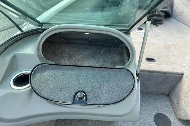 Slide: The Image of 2012 Smoker Craft Pro Angler XL 162 boat storage compartment with open lid and cup holder. - 17