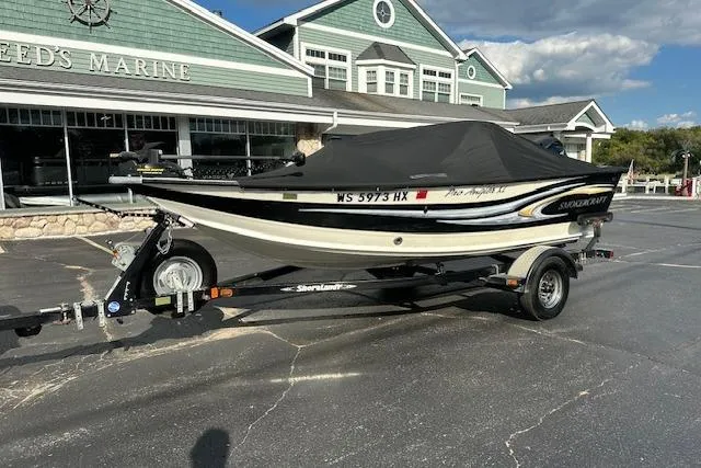 Slide: The Image of 2012 Smoker Craft Pro Angler XL 162 boat on trailer, parked outside marine store. - 20