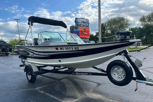 Slide: The Image of 2012 Smoker Craft Pro Angler XL 162 boat on trailer, parked outdoors under cloudy sky. - 3