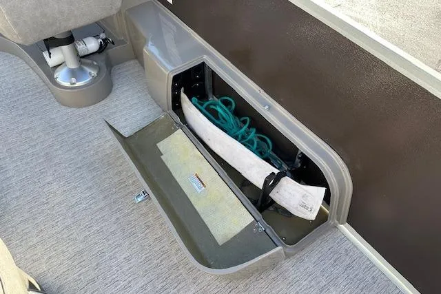 Slide: The Image of Open storage compartment in a 2019 Premier 220 Gemini boat, showing ropes and equipment. - 18