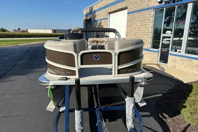Slide: The Image of 2019 Premier 220 Gemini pontoon boat displayed outside a building on a sunny day. - 2