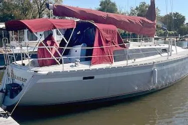 The Image of 1988 O'Day 322 sailboat with maroon covers docked in a marina. - 0