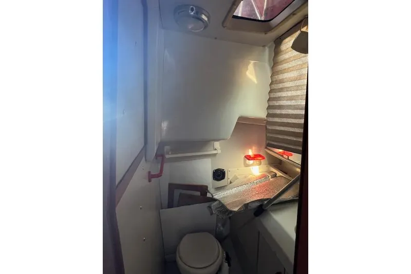 Slide: The Image of 1988 O'Day 322 sailboat bathroom with toilet, window, and compact design. - 17
