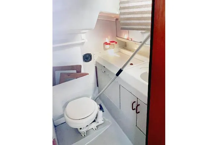Slide: The Image of 1988 O'Day 322 sailboat bathroom with toilet, sink, and storage cabinets. - 18